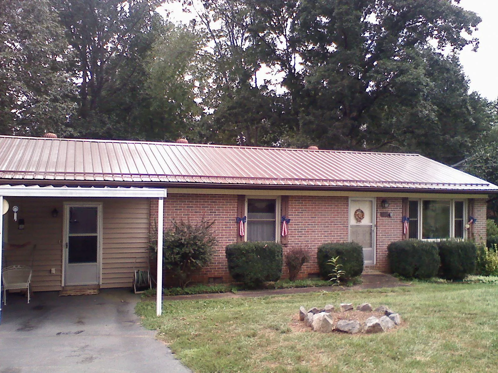 Bronze metal roof and carport on a brick ranch home — Roof Repair work by our crew in Radnor